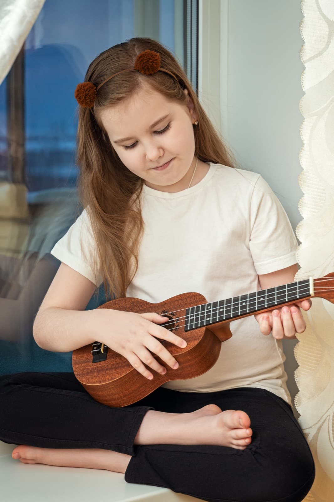 Criança com ukulele em momento afetivo e divertido