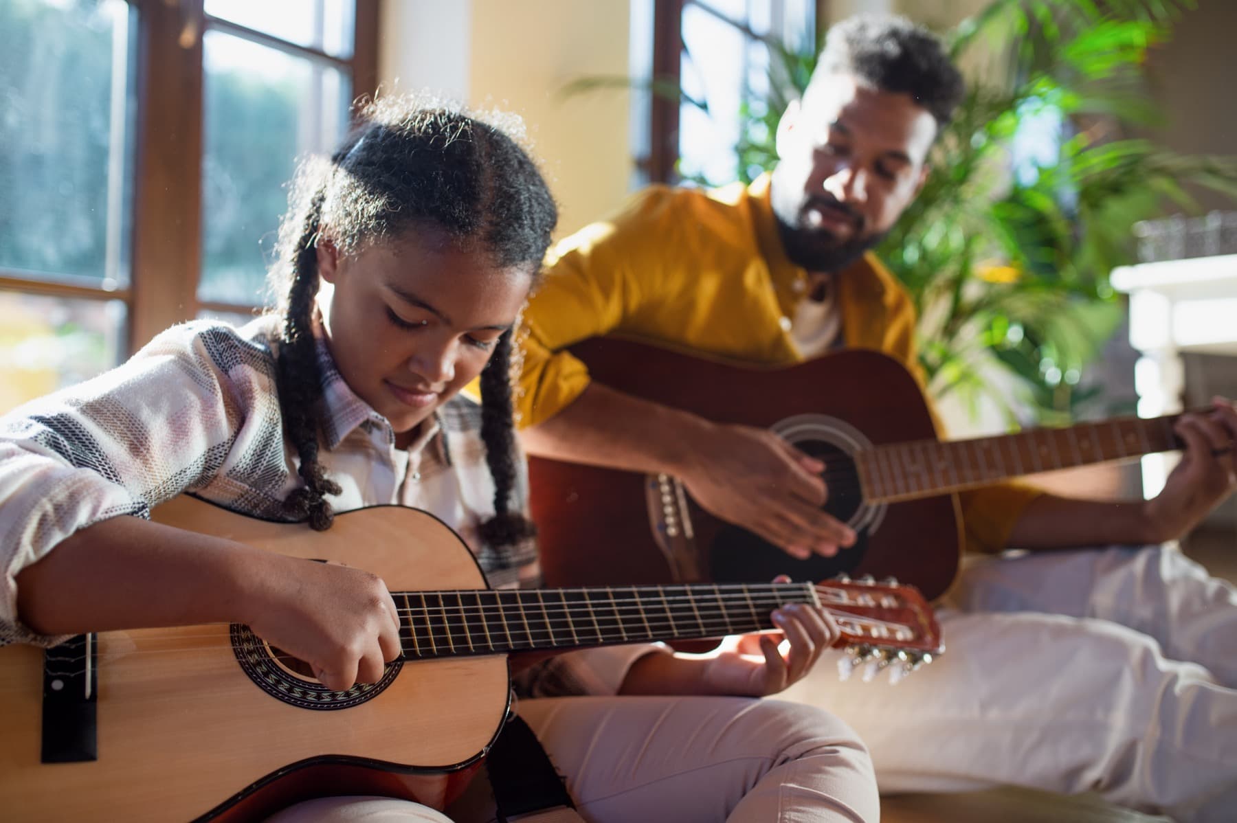 Pai e filha em momento musical afetivo em casa